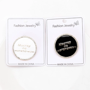 Détail de broches rondes en émail noir et blanc avec strass et texte russe gravé