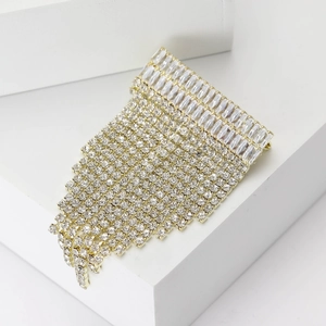 Élégante broche dorée à pampilles avec franges en strass de luxe sur fond blanc pur