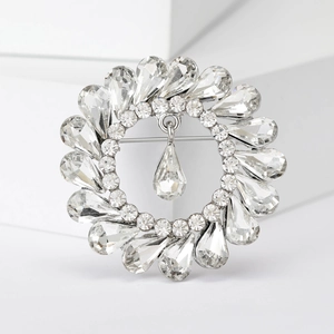 Macro detail of silver vintage wreath brooch with sparkling crystals and teardrop pendant