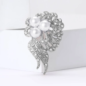 Elegant rhinestone flower brooch with white pearls and silver alloy petals on white background
