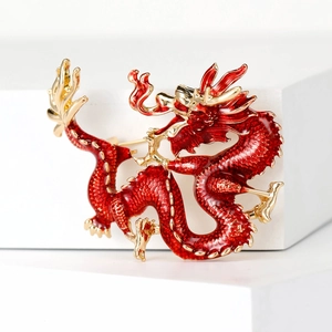 Elegant Chinese dragon brooch with red enamel and gold-plated details on white background