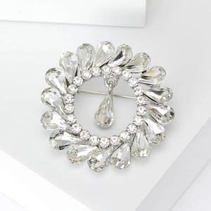 Detailed macro view of a silver crystal flower brooch with a dangling teardrop pendant