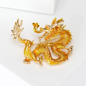 Macro shot of detailed enamel Chinese dragon brooch with golden scales on white stand