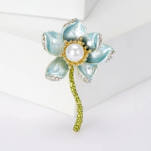 Elegant blue lotus flower brooch with pearls and crystals on a white pedestal