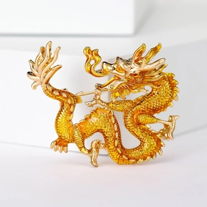 Exquisite close-up of a golden enamel dragon brooch with intricate scales on a white stand