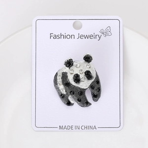 Détail macro d'une broche panda avec cristaux noirs et blancs sur carte de bijouterie