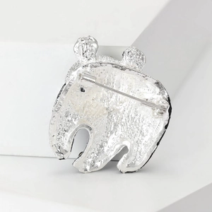 Broche ours argentée vue arrière avec texture martelée et épingle de sûreté sur blanc