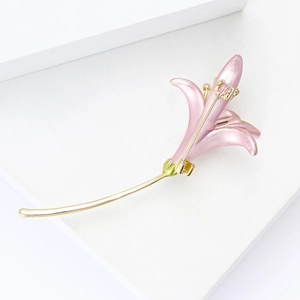 Macro detail of elegant pink lily brooch with golden stem and secure safety pin clasp