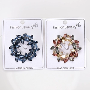 Detail of floral wreath brooches with colorful marquise crystals on white cards