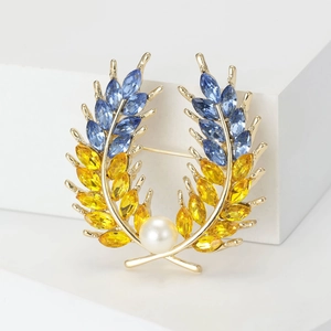 Détail de la broche épi de blé avec cristaux bleus et perle blanche sur métal doré