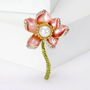 Detailed close-up of a lotus brooch with pink enamel petals, white pearl and small rhinestones
