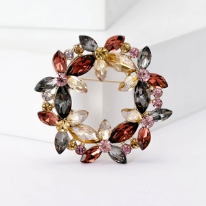 Elegant crystal wreath brooch with amber and red gemstones on gold metal stand