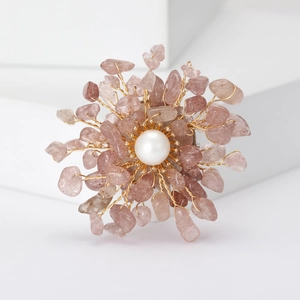 Macro shot of handmade flower brooch featuring natural strawberry quartz and pearl