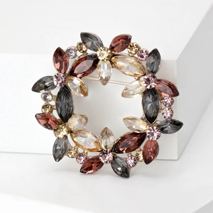 Detail of crystal wreath brooch with multi-colored gemstones and gold-plated setting