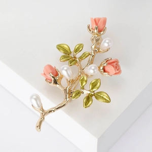 Élégante broche fleurie dorée avec roses roses, feuilles vertes et perles blanches sur support