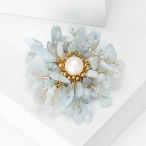 Detailed view of handmade flower brooch with natural blue stones and white pearl