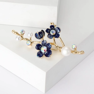 Détail de broche branche fleurie avec pétales en émail bleu et perles blanches