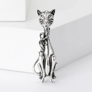 Vintage silver cat brooch with bow detail on white minimalist geometric pedestal