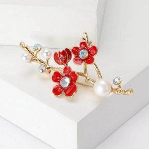 Détail de la broche branche de prunier avec émail rouge et perles blanches