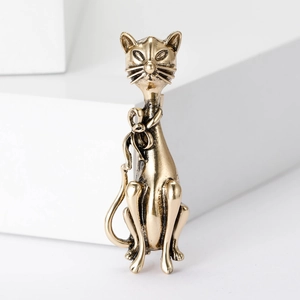 Vintage style gold-toned cat brooch with bow detail, elegant accessory for coats and dresses