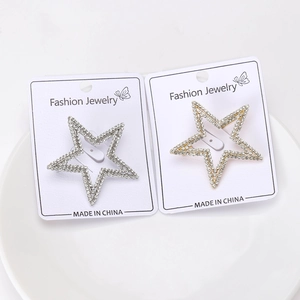 Detailed view of rhinestone studded star brooches in gold and silver finish on a display