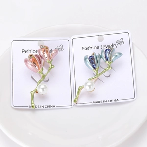 Detailed close-up of magnolia brooches with crystal petals and elegant large white pearl