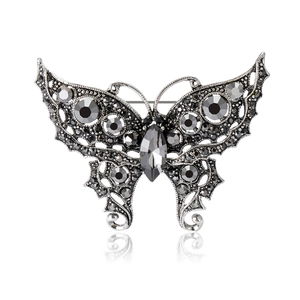Vintage silver butterfly brooch with grey rhinestones and marquise crystal on white background
