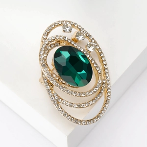 Vintage gold oval brooch featuring a large green gemstone and shimmering crystal accents
