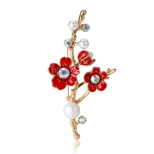 Élégante broche fleur de prunier avec pétales rouges et perles sur branches dorées