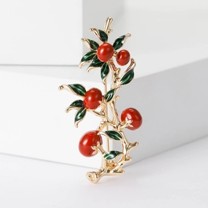 Chinese style persimmon brooch with red beads and golden metal finish on white blocks