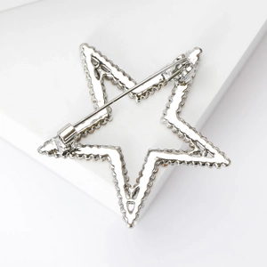 Detail of star brooch back featuring a secure rotating pin clasp on silver metal