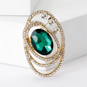 Elegant vintage oval emerald crystal brooch with gold layered rings and pavé rhinestones
