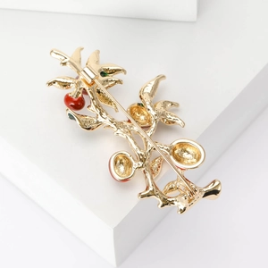 Elegant Chinese style golden branch brooch with red fruit and green leaves on white stand