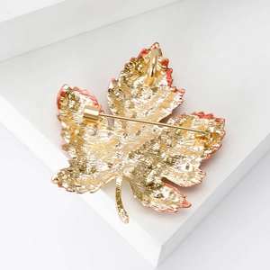 Broche élégante en forme de feuille d'érable dorée avec bord rouge et cristaux brillants