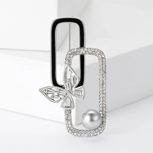 Detail of silver butterfly brooch with black enamel, sparkling rhinestones and grey pearl