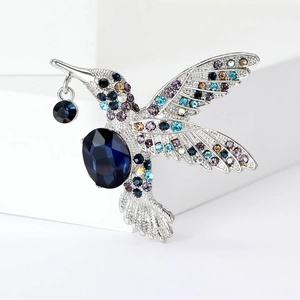 Détail de la broche colibri ornée de cristaux colorés et d'une pierre bleue