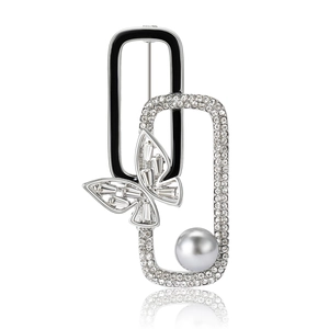 Elegant butterfly pearl brooch with black enamel and crystals on white background