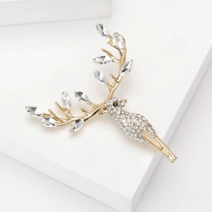 Elegant gold reindeer brooch with marquise crystals and rhinestones on a white stand