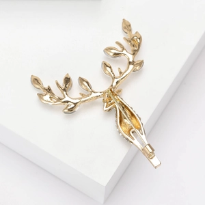 Elegant gold reindeer antler brooch with sparkling rhinestones on a geometric stand