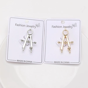 Detail of creative compass brooches in gold and silver alloy finish on display cards