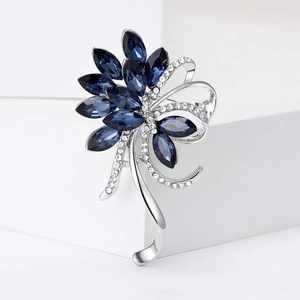 Detail of elegant silver flower brooch with deep blue crystals and white rhinestones