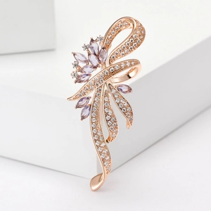 Macro-opname van strikbroche met roségouden plating, zirkoon en paarse edelstenen