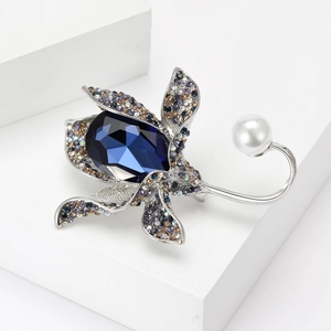 Close-up of floral brooch with blue teardrop crystal, multicolored rhinestones and pearl