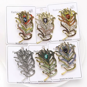 Detailed close-up of peacock feather brooches with multi-color rhinestones and retro base