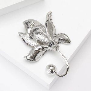 Elegant floral orchid brooch with pearls and crystals on a white minimalist background
