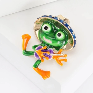 Dettaglio della spilla principe ranocchio in smalto verde con accessorio chitarra mini