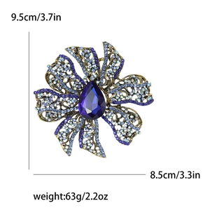 Detail showing rhinestone flower brooch dimensions 9.5cm by 8.5cm with blue pear-cut stone