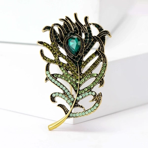Macro detail of elegant peacock feather brooch with emerald green crystal and rhinestones