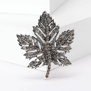 Close-up of maple leaf brooch with silver metal and smoke grey rhinestones
