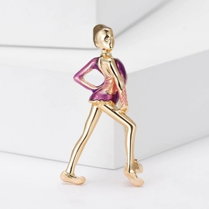 Macro detail of gold-plated skater brooch with purple gradient enamel on white stones